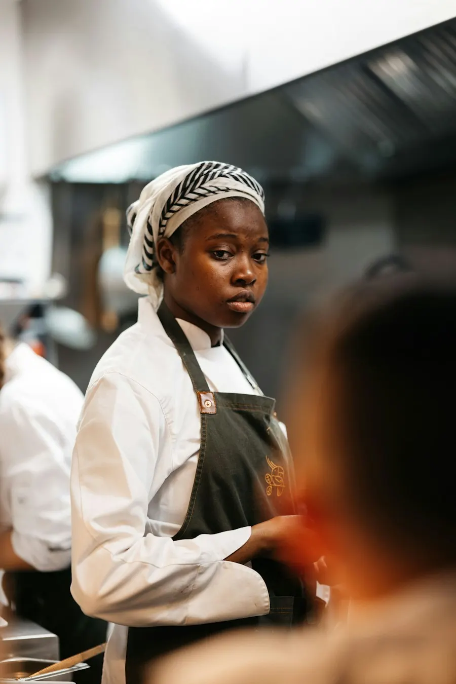 Ada Okafor in chef’s whites in the Ember & Oak kitchen