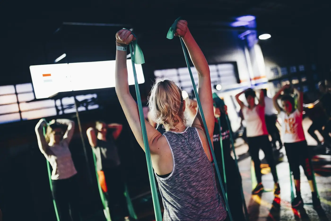 A packed evening class stretching with resistance bands