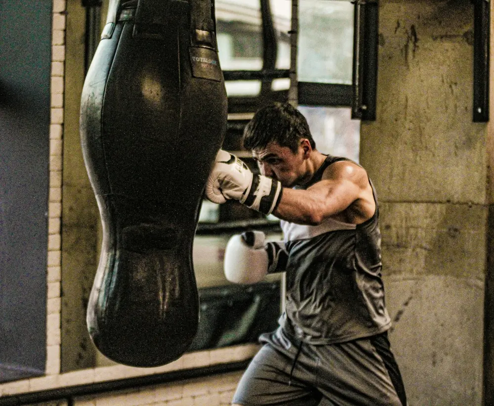 Boxer hitting a heavy bag in the boxing area