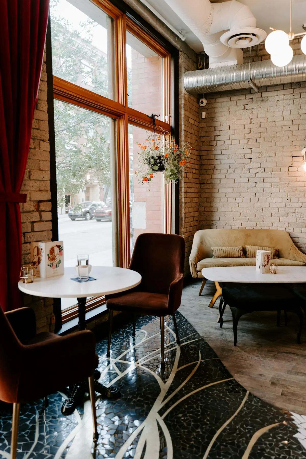 Small corner café with brick walls, tall windows and a leather armchair