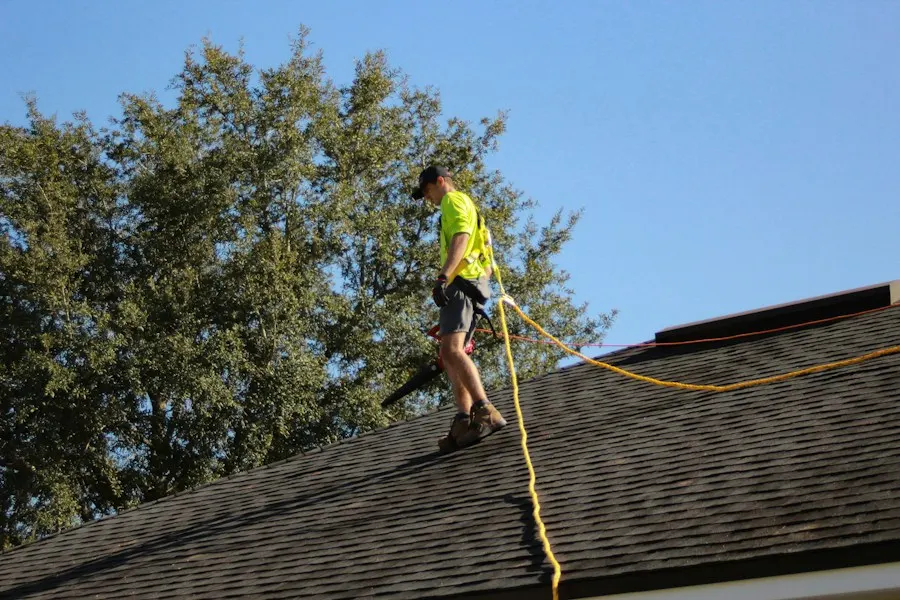 A Northline roofer clipped to a safety line, checking a roof after a storm