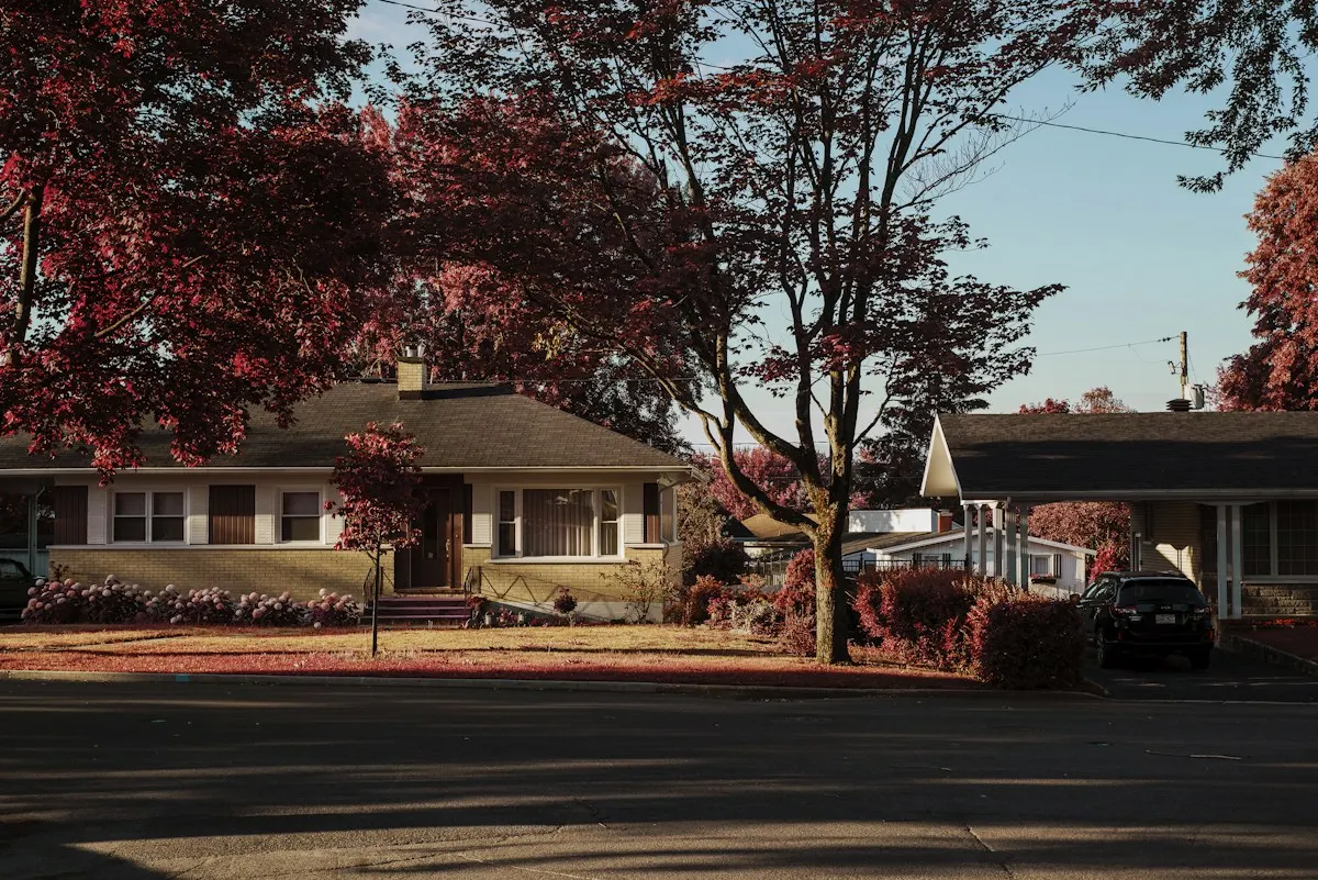 Brick bungalow on a tree-lined street in autumn
