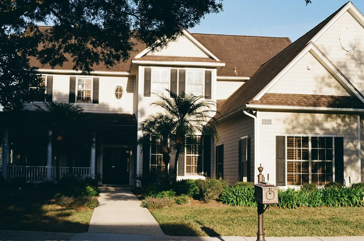 Two-story white colonial home with a new charcoal shingle roof