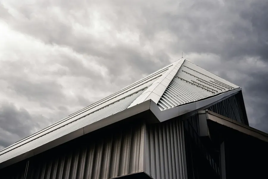 Standing-seam metal roof ridge against a cloudy sky